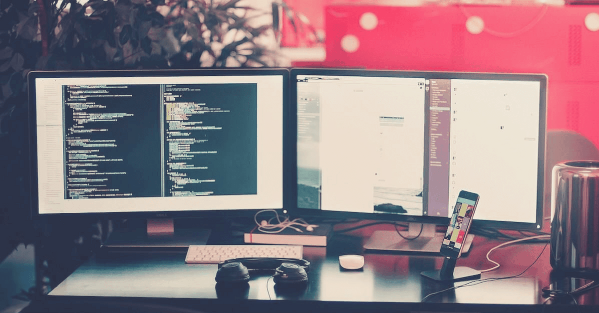 A photo showing a desk with two active computer monitors.