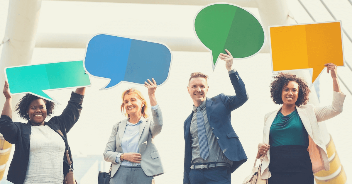 Four people holding different-colored speech bubbles signs over their heads.