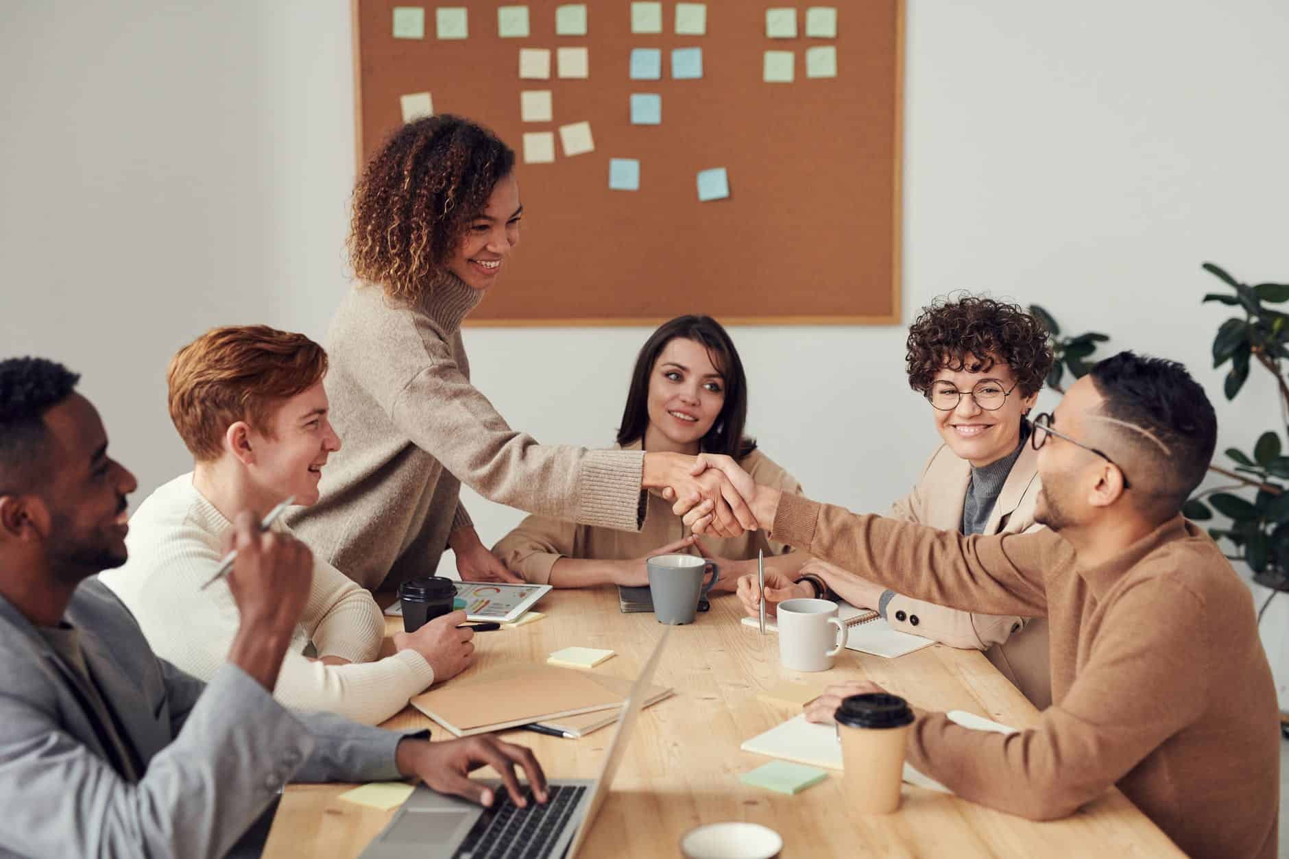 diverse group of people handshaking at a sale meeting.