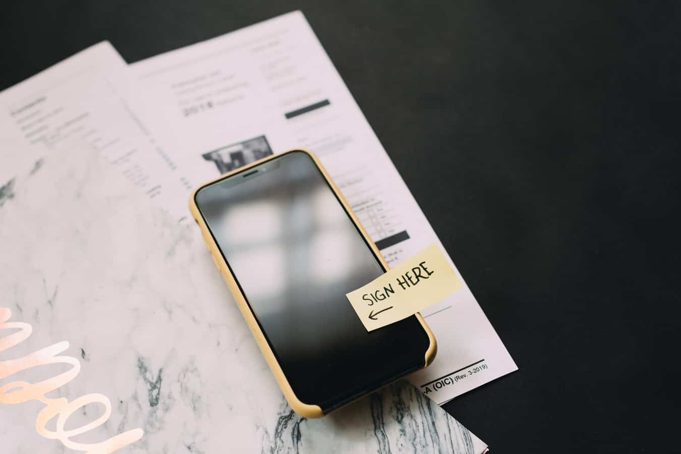 Mobile Phone with a "Sign Here" sticky note