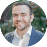 Circular photo of man with beard in shirt and suit jacket, smiling