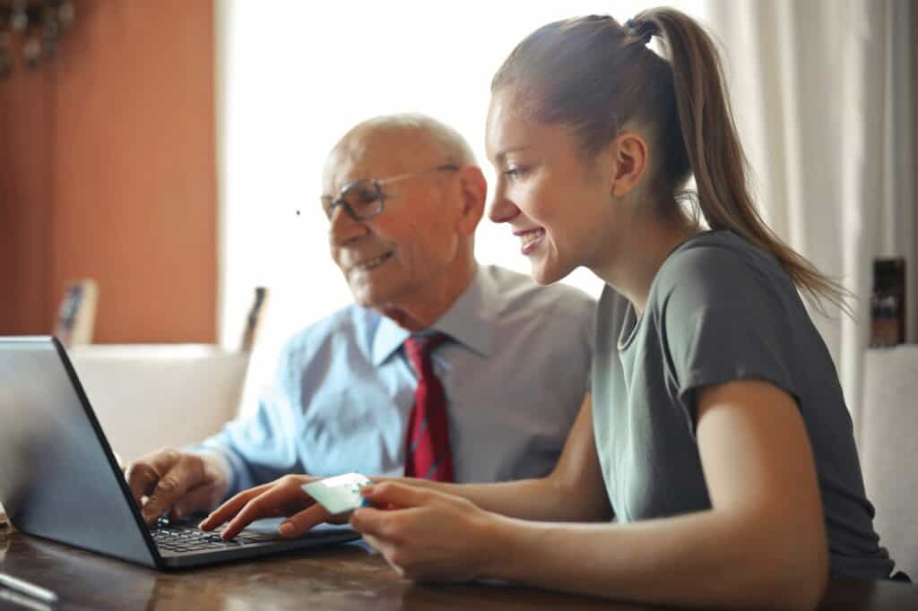 Woman with elderly man looking at a computer.