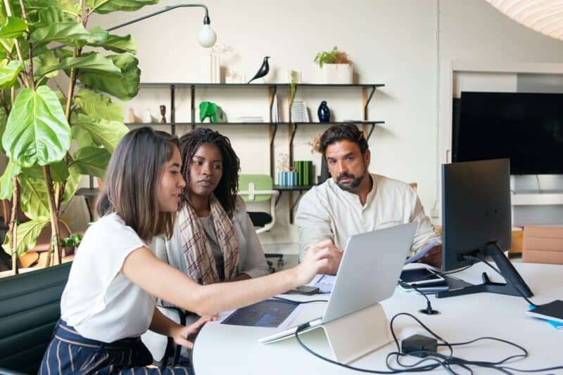 Team of agency owners around a laptop