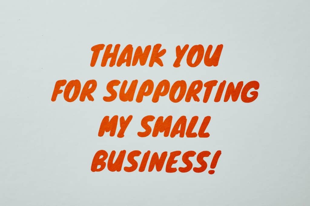 Hand-painted sign thanking customers for supporting a small business. 