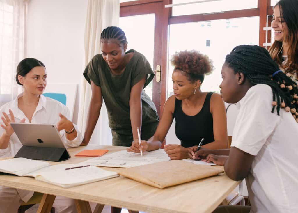 Four women collaborating around a work table. 