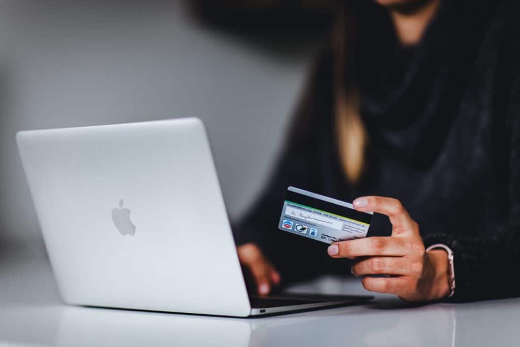 Woman making purchase on laptop with credit card in hand