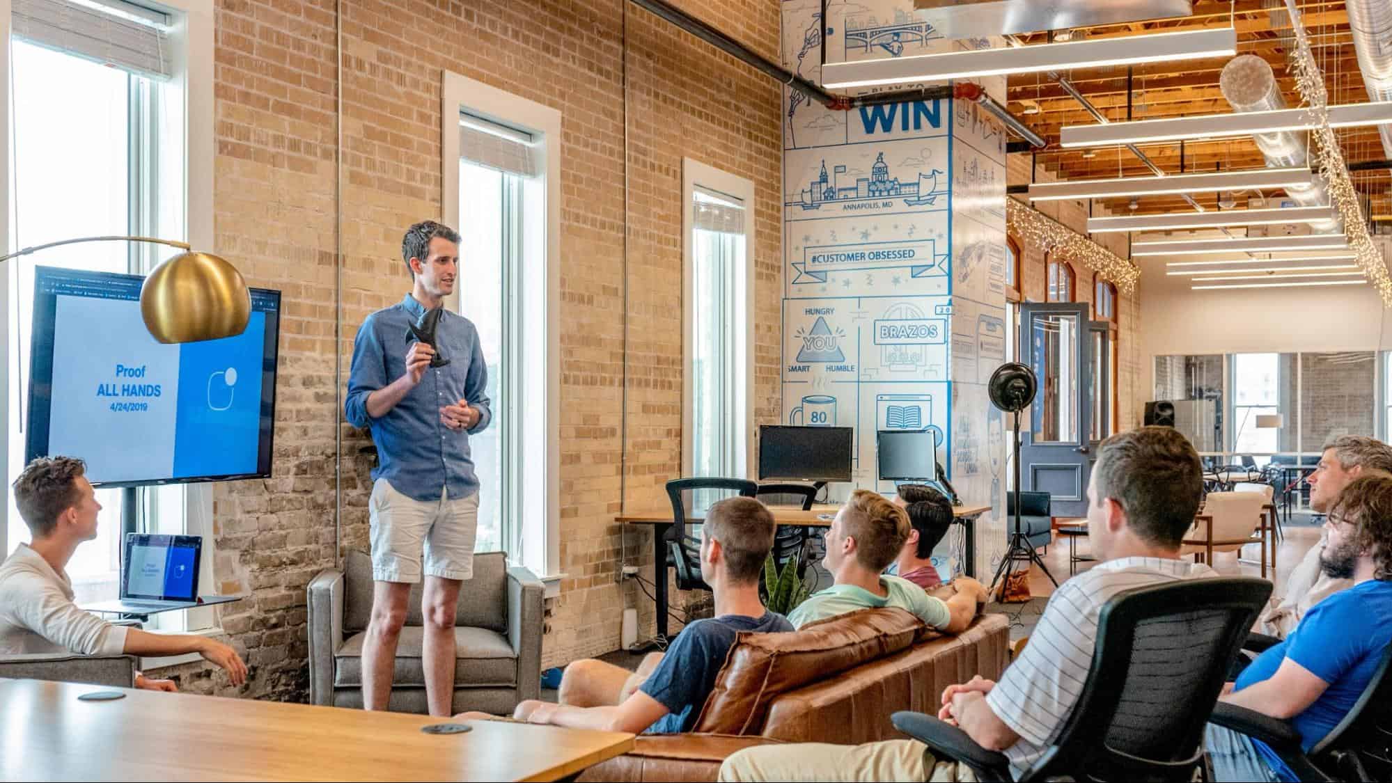 A man addressing a group of men in an office