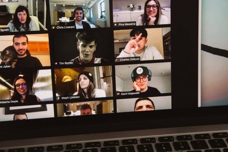 A Macbook Pro displaying the faces of participants on a video conference call